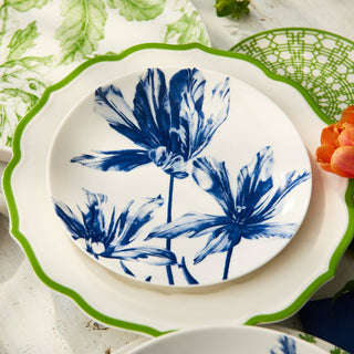 White plate with blue floral design on a green and white patterned tablecloth.
