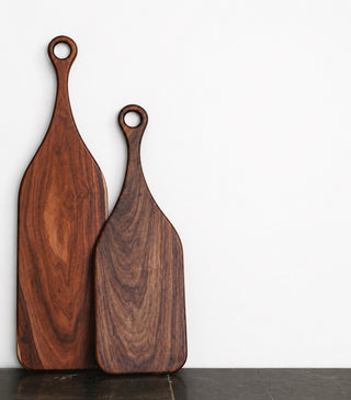 Two wooden cutting boards with handles on a white background
