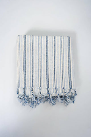 Home & Loft Turkish Towel White with Dark and Light Blue stripes of varying widths and tassels.