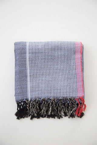 Home & Loft Turkish Towel Indigo with White and Soft Red stripes of varying widths and tassels.