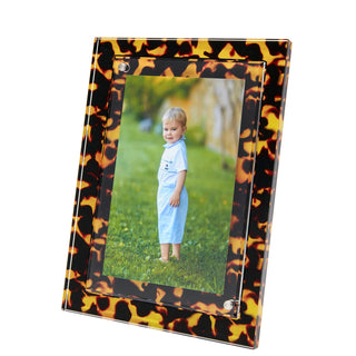 Tortoise acrylic photo frame by Tara Wilson Designs. With a detachable kickstand, it orients both vertically and horizontally. Plus, you can use either a 4 x 6 or 5 x 7 photo. Dimensions: 6" x 8"