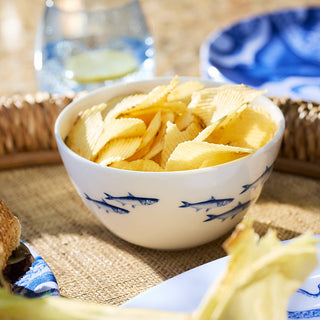 Bowl of potato chips on a woven mat with a blurred background
