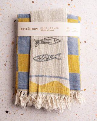  Set of two cotton towels by Olive & Loom.
Set of One towel features a classic checkered weave in contrasting tones, while the other steals the show with a playful, hand-stitched Mediterranean inspired design—perfect for foodies and entertainers alike. Each towel measures 20x30 inches, making them as functional as they are decorative.  