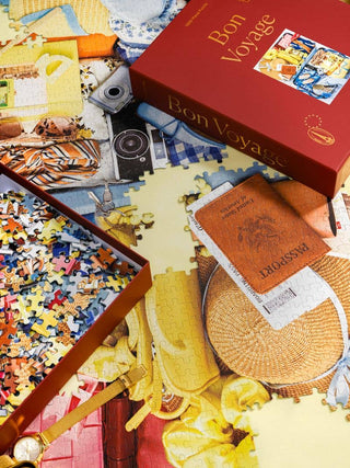 Jigsaw puzzle with travel-themed pieces and a 'Bon Voyage' box.