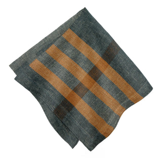 Maison Marigold set of four Modern Plaid napkins in navy and chestnut. Featuring bold diagonal stripes in warm tan and brown, shown on a plain white background.