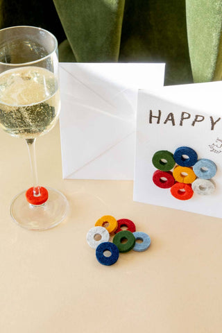 Wine-Ote's Felt Wine Marker Note Cards are an extension of our best selling Merino wool felt wine markers Wine-O’s. Multicolored felt markers displayed on a Happy notecard.