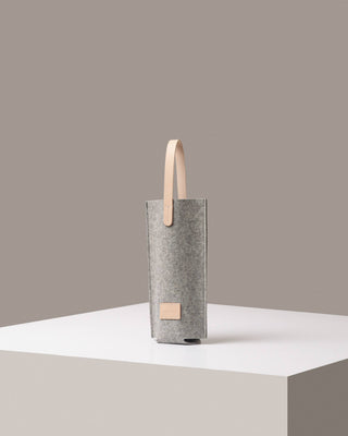 Graf Lantz wine carrier in grey merino wool felt with light natural leather handle and label on a white pedastal