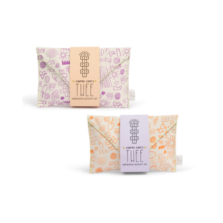 Two canvas pouches with printed activities for children's play, one in orange and one in purple, with the brand name 'TWEE' visible.