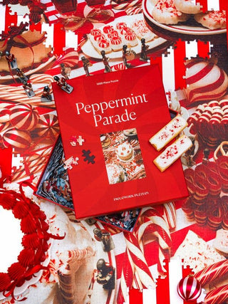  A confectionary still life packed with swirls and stripes— layer cakes, candy canes, peppermint drops, and toy soldiers marching straight through dessert. Festive and unapologetically sweet, this 1000-piece puzzle  by Piecework Puzzles captures the joyful excess of the season, one minty moment at a time.