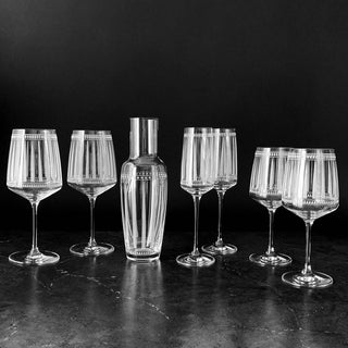 Set of crystal wine glasses and a carafe on a dark surface with a black background