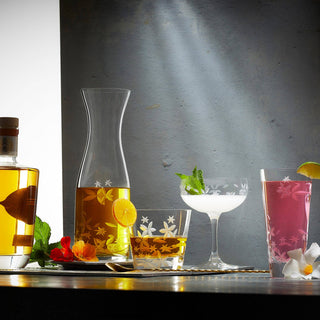 Alcohol bottles and glasses with drinks on a reflective surface
