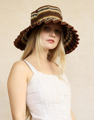 Grass fibre woven hats features horizontal bands of cacao-brown, rust and cream coloured thread woven in an overlapping vertical striped pattern through its natural fibre base, with cacao-brown coloured fabric trimming. UPF 50
