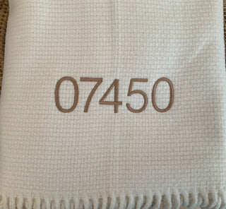 A Soft Idea Throw is a 50% cotton, 50% microfiber acrylic throw. It is designed to be durable and machine washable, and is made in Spain. The throw measures 55” x 70”. Perfect for any home. This throw is embroidered with a zip code.