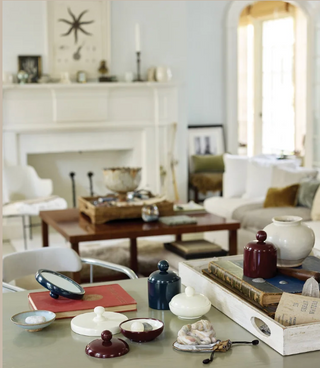 Living room with a coffee table displaying decorative items and a fireplace in the background.
