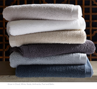 Stack of Matouk Aman Bath Towels in Cloud, White, Nude, Anthracite , Pool and Baltic.