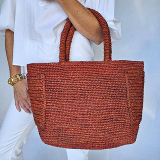 Baldiz Raffia beach tote with handle in rust. Has pockets on the outside and inside,