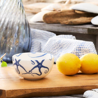Caskata Starfish White ceramic snack bowl with blue octopus design on a wood board with lemons