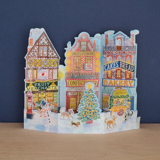 Art Angels advent calendar with a picture of assorted main street merchants decorated for Christmas.