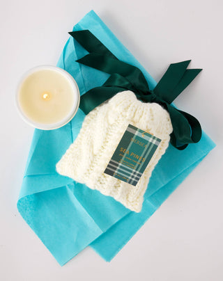 Sea pines Candle  6.5 oz by Mersea with scents of pine,cedar and balsam. This candle comes in a woven stocking bag topped with a silky ribbon bow. 