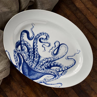 Caskata Lucy white serving tray with blue octopus design on a wooden background