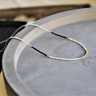 Seed bead necklace with mixed color pattern with gold beads mixed throughout. Length 16”