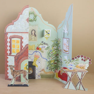 Art Angels festive gable advent calendar with 25 windows. Depicts a homey and festive room decorated for the holiday. 