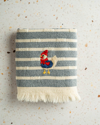 Striped towel with a rooster design on a textured surface