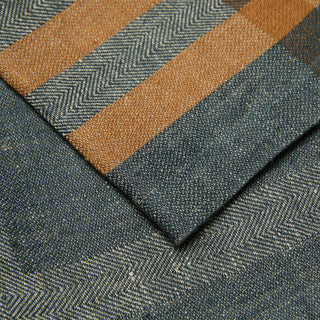 Modern Plaid Napkins Navy & Chestnut 20x20 close-up of woven fabric with a plaid pattern, showing alternating bands of dark blue-gray herringbone and warm tan/ochre chevron weave.