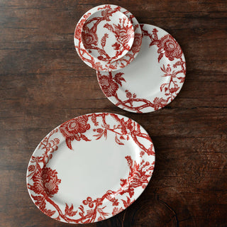 Caskata Arcadia Crimson Set of red floral-patterned plates on a wooden surface