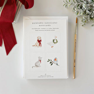 Emily Lex Studio festive friends note cards includes a pup in a red bow, a goose wearing a wreath, a cat with ribbon round her neck, a robin perched on holly — four little creatures dressed for the season. Sketched on watercolor paper and ready for your colors. Simple instructions included. Details: - set of eight paintable notecards + envelopes - two of each illustration lightly sketched for you to paint - blank inside - 5" x 7" - Printed on 120lb watercolor paper