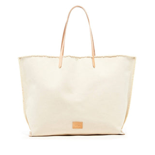 the Hana canvas Boat bag can sling over the shoulder making for a unique and beautiful carryall. Features include deconstructed edges, premium Vegetable tanned leather, an interior pocket, and a nickel snap closure. Due to the artisanal and hand finished nature of the fraying technique you may experience loose threads that make their way out of the unfinished edges up until the stitching around the edge of the bag.